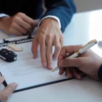 Hands signing an insurance agreement for auto repair services